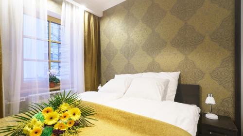 a bedroom with a bed with a flower arrangement on it at AntoniasLuxApart Free Parking in Rīga