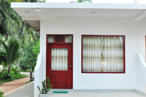 a red door and window in a white house at Sea View Villa Bentota, Induruwa in Induruwa