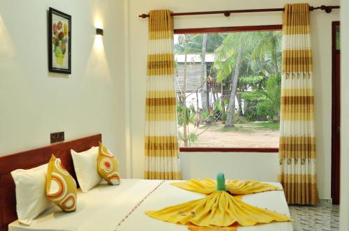 因杜魯瓦的住宿－Sea View Villa Bentota, Induruwa，一间卧室配有一张带窗户的床和床罩