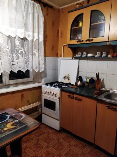 uma pequena cozinha com um fogão e um lavatório em посуточная аренда Прокофьева 36 em Sumy