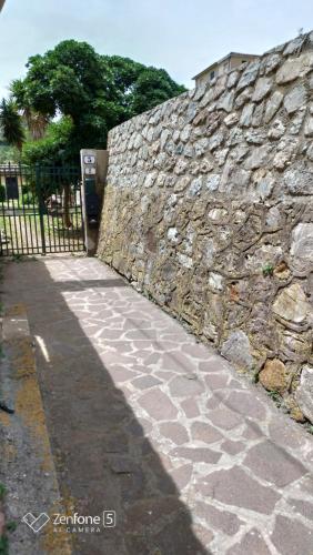 un muro di pietra e un marciapiede accanto a una recinzione di Appartamentino Bianco a Rio Marina