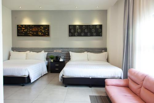 2 camas en una habitación de hotel con sofá en M Design Hotel @ Shamelin Perkasa en Kuala Lumpur