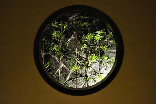 a window with a plant in the center of it at Nagi Kyoto Sanjo in Kyoto