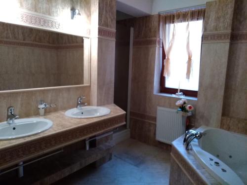 La salle de bains est pourvue de 2 lavabos, d'une baignoire et d'une fenêtre. dans l'établissement Brezno 2 izbovy Apartman Sabi, à Brezno
