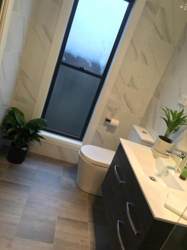 Executive Villa, private 2 bedroom in ideal location في باثورست: حمام مع نافذة ومرحاض ومغسلة