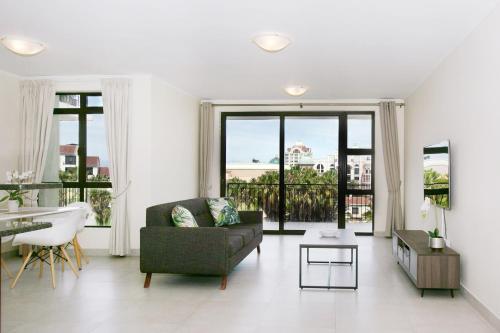 a living room with a couch and a table at Island Club Hotel & Apartments in Cape Town