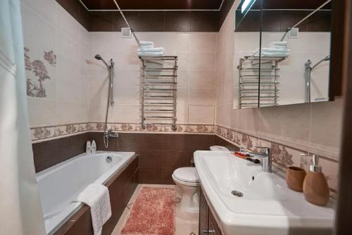 y baño con bañera, aseo y lavamanos. en PaulMarie Apartments on Prs. Lenina, 51, en Gomel