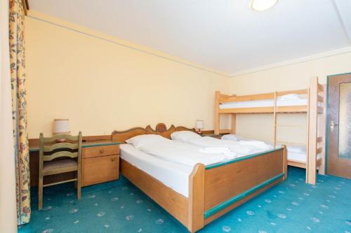 a bedroom with two bunk beds and a desk at Mountain Hotel & Hostel in Ramsau am Dachstein