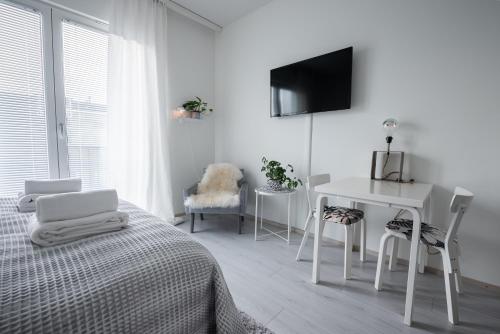 a bedroom with a bed and a desk and a tv at Compact high quality top floor studio in perfect location in Oulu