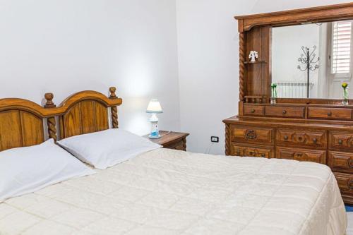 a bedroom with a bed and a dresser and a window at Pink liberty house in Santa Croce Camerina
