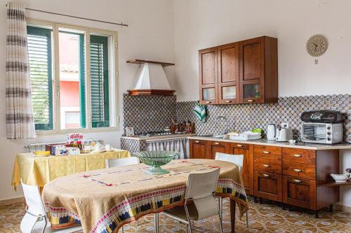 a kitchen with a table and chairs and a kitchen with a counter at Pink liberty house in Santa Croce Camerina