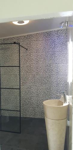 La salle de bains est pourvue de toilettes et d'une douche en verre. dans l'établissement Au chant du coq, à Salazie