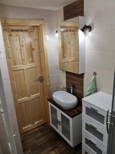 a bathroom with a sink and a toilet and a door at Chata Osmička in Zlaté Hory
