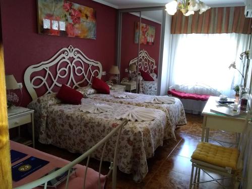 1 dormitorio con 1 cama con paredes rojas en Hostal Camino de Santiago, en Frómista