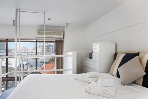 1 dormitorio con cama blanca y ventana grande en S203S - The Loft by Darling Harbour, en Sídney