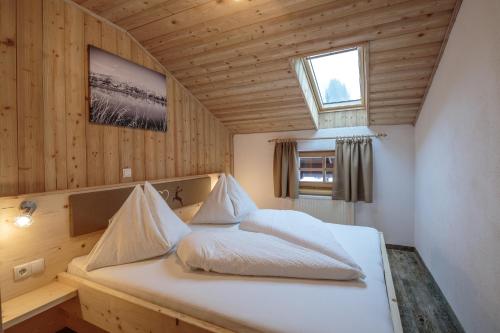 a bedroom with a white bed with a window at Appartements Grünholz in Itter