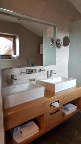 a bathroom with two sinks and a large mirror at Hotel Tyrolis in Zirl