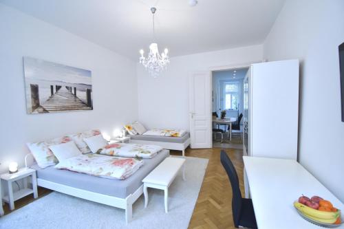 Sala de estar blanca con sofá y mesa en Cosy 3 Room Viennese Flat - 10min to City Center, en Viena