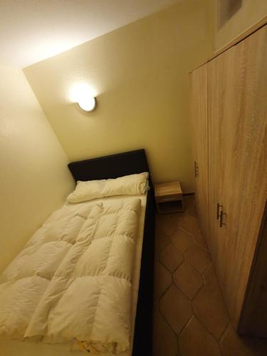 ein kleines Bett in einem kleinen Zimmer mit einer Lampe in der Unterkunft Ferienwohnung Am Paradies in Bad Lauterberg