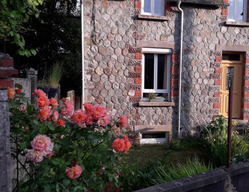 una casa de piedra con flores delante en Chambre d hôte chez Fany en Mur-de-Bretagne