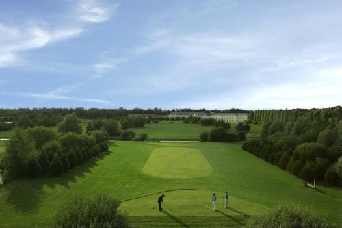 a group of people playing golf on a lush green field at Mercure Chantilly Resort & Conventions in Chantilly