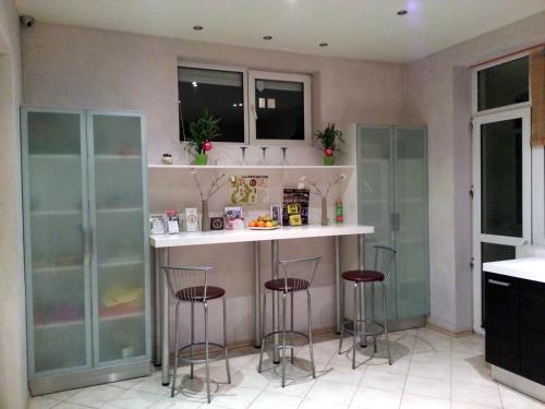 a kitchen with a bar with stools and windows at Elegance on a Budget - Rooms for Rent in Sofia Center in Sofia