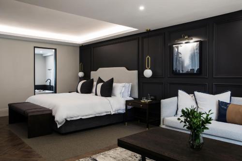 a bedroom with a large bed and a couch at Seven Villa Hotel & Spa in Johannesburg