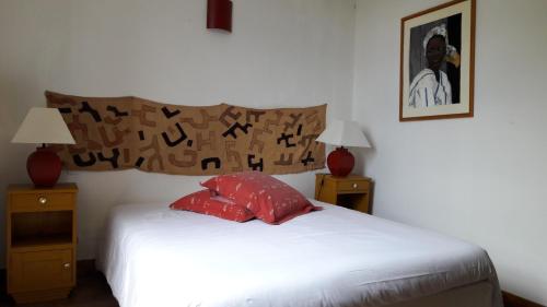 een slaapkamer met een bed met 2 nachtkastjes en 2 lampen bij Le Maine au bois in Saint-Vallier