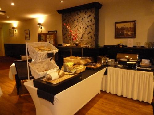 a buffet in a restaurant with food on a counter at Hotel Centraal in Harlingen