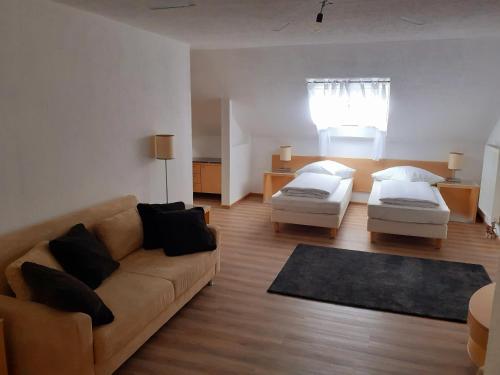 uma sala de estar com um sofá e 2 camas em Apartment City Metzingen em Reutlingen