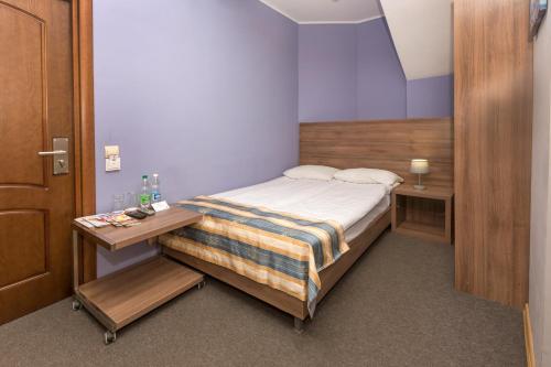 a small bedroom with a bed and a table at Lviv Central Jam Hotel in Lviv