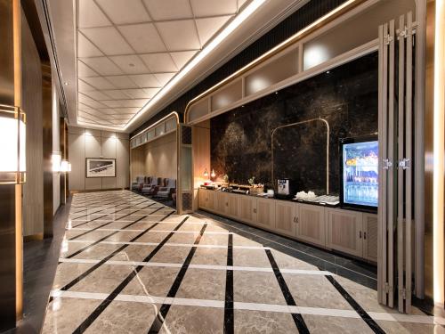 a lobby with a television and a large screen at ibis Bangkok Sukhumvit 24 in Bangkok