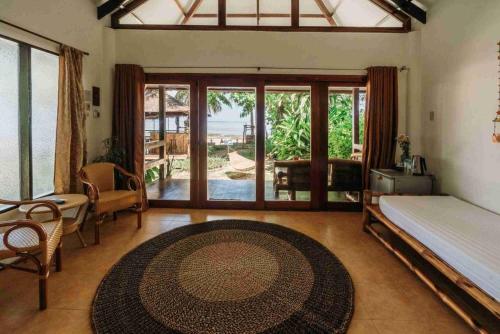 a bedroom with a bed and a large glass door at Romantic Beach Villas in General Luna