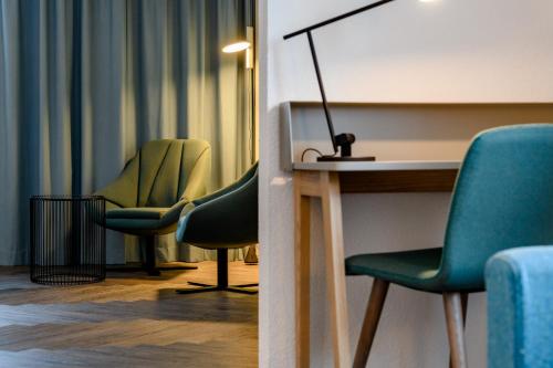 a room with two chairs and a table and a lamp at Novotel Zurich City West in Zürich