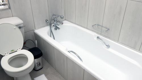a bathroom with a toilet and a bath tub at The Observatory, Luxury Suite in Observatory Home in Johannesburg