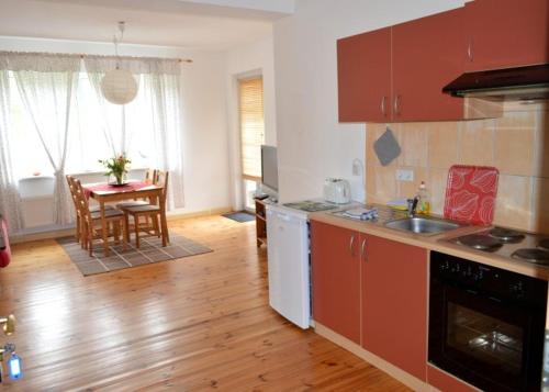 a kitchen with a wooden floor and a table with a dining room at Unsere Ferienwohnung Stefan im Riesengebirge! in Dolní Lánov