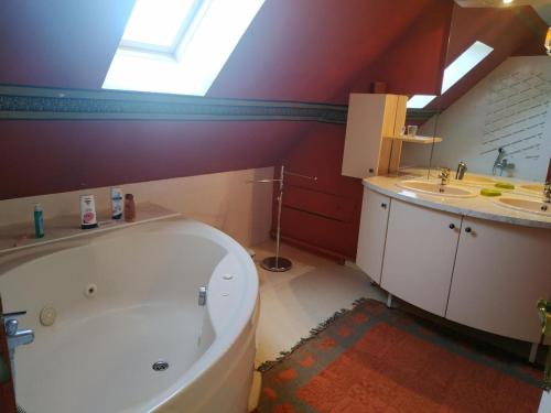 ein Badezimmer mit einer großen weißen Badewanne und einem Waschbecken in der Unterkunft CHEZ MARLYSE in Blois
