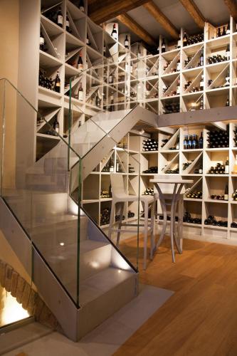a glass staircase in a wine cellar with a table and chairs at Hotel Ad Gallias in Bard