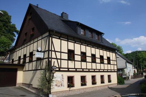 a white and black building with a black roof at Doppelzimmer-in-Wiesa in Thermalbad Wiesenbad