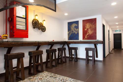 a bar with wooden stools in a room at M Design Hotel @ Taman Pertama in Kuala Lumpur