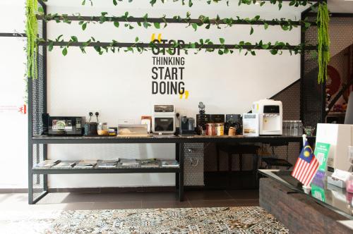 a room with a table with a sign that reads thinking start doing at M Design Hotel @ Taman Pertama in Kuala Lumpur