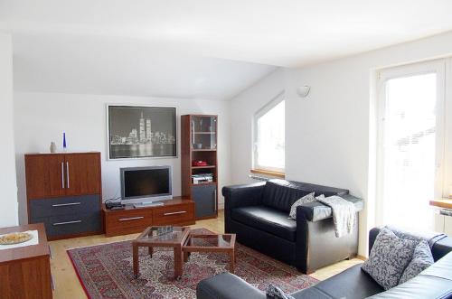 a living room with a couch and a tv at Apartment Zupan in Maribor