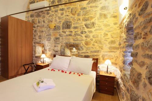 ein Schlafzimmer mit einem Bett und einer Steinmauer in der Unterkunft STOES Traditional Suites in Mestá