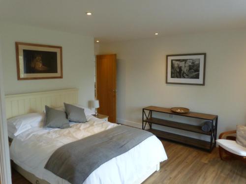 a bedroom with a large bed and a table at The Woodshed - A newly built, 2 bedroom, cottage near Glastonbury in Glastonbury