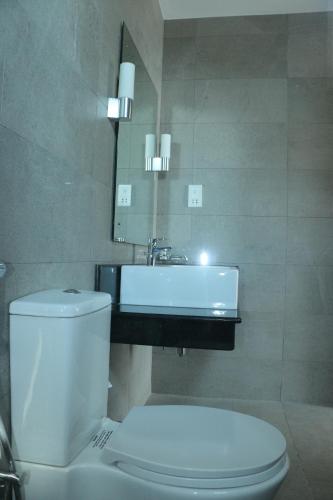 a bathroom with a white toilet and a sink at BEACH HAVEN NILAVELI in Nilaveli