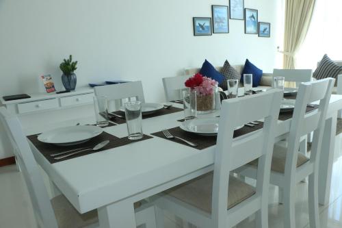 una mesa de comedor blanca con sillas blancas, una mesa blanca y un sillón en BEACH HAVEN NILAVELI, en Nilaveli