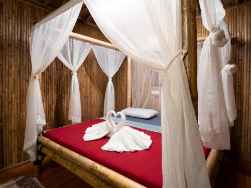 a bedroom with a bed with two white towels at Tadom Hill Resorts in Kampong Labohan Dagang