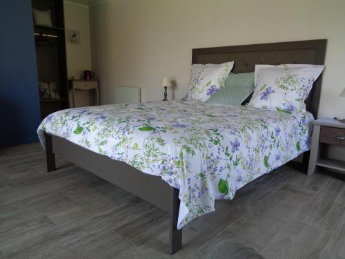 1 dormitorio con 1 cama con edredón morado y verde en la Monlassière, en Vitry-aux-Loges