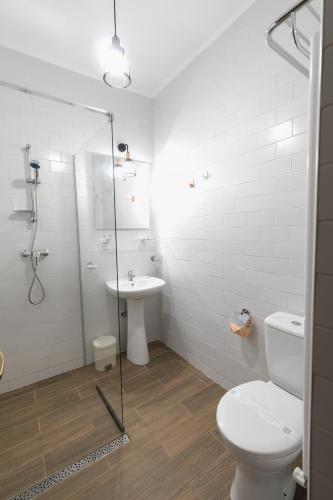 a bathroom with a shower and a toilet and a sink at Villa Ciao - Adults Only in Corbu