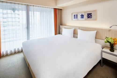 京都的住宿－馨樂庭京都烏丸五條酒店，窗户客房内的一张大白色床
